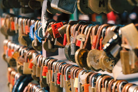 Close up shot of rusty old love locks hanging on the bridgeの写真素材