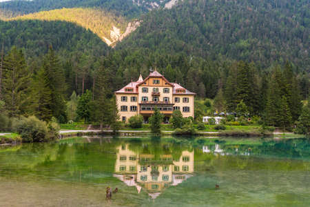 White lake house in the deep forest on the lake shoreの写真素材