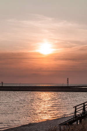 Orange sun rays reflecting in water of Baltic sea in summerの写真素材