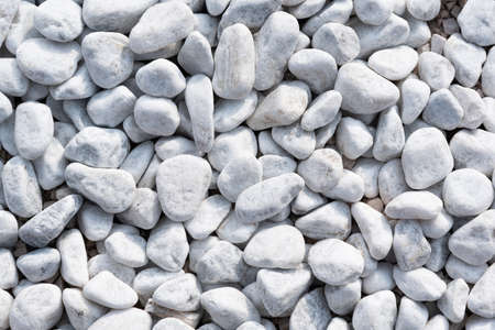Small white stones on the ground on a close up shotの写真素材