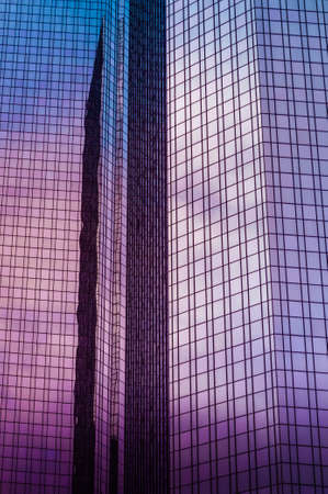 Modern glass office building close up with the sky reflectingの写真素材