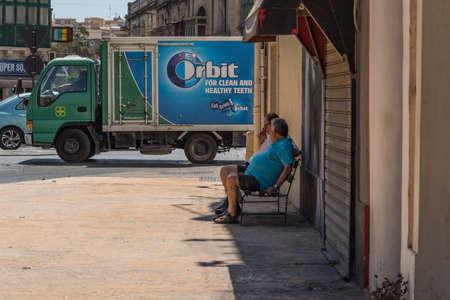 Tarxien, Malta - 20 June, 2019 - Two men observing the chewing gum truck after good lunchのeditorial素材