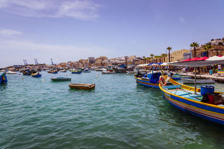 Marsaxlokk, Malta - June 22, 2019 - small boats and houses of local people living in fishing villageのeditorial素材