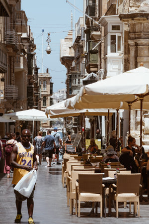 Valletta, Malta - June 20, 2019 - narrow central streets and people walking between restaurants and shopsのeditorial素材