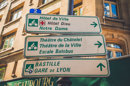 Paris, France - Apr 20, 2019 - three tourist road signs on the pillar and an old building on the backgroundのeditorial素材