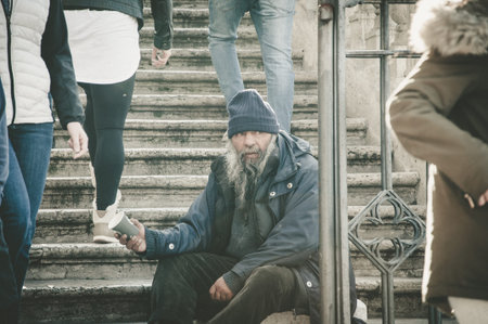 Rome, Italy - Dec 25, 2017 - Homeless man near the church, sitting on the stairsのeditorial素材