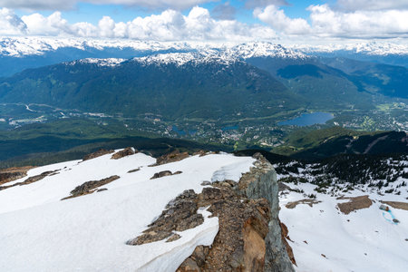 View from the top of the mountain with snow and valley in the backgroundの写真素材
