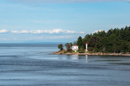 Red and white lighthouse in the middle of the Pacific Ocean near Canadian borderの写真素材