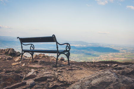Park bench standing on the edge of the high mountain in Czech Republic with amazing view on the backgroundの写真素材