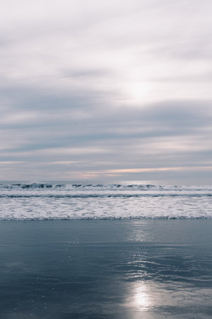 White sun light behind clouds above Pacific Oceanの写真素材