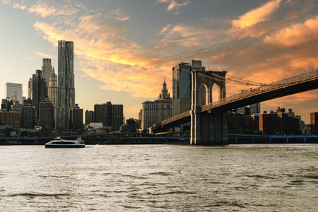 New York, US - May 10, 2023 - Late afternoon sun reflections on Brooklyn bridge and financial...