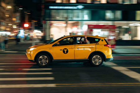 New York, US - May 12, 2023 - Traditional New York taxi in the night with couple of tourists on...