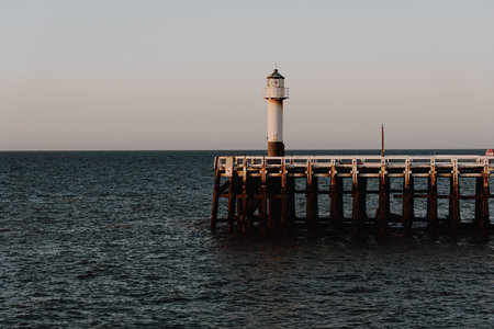 Lighthouse on the pier during late sunsetの写真素材