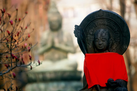 Two buddha statues with red towel