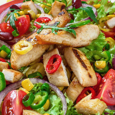 Mexican spicy chicken salad on the plate. Grilled chicken meat with tasty selection of vegetables.の写真素材