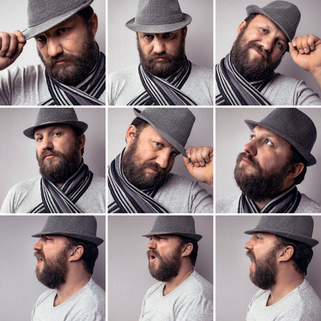 Bearded young hipster man wearing gray hat and scarf, fashion portrait against gray wall. Side...