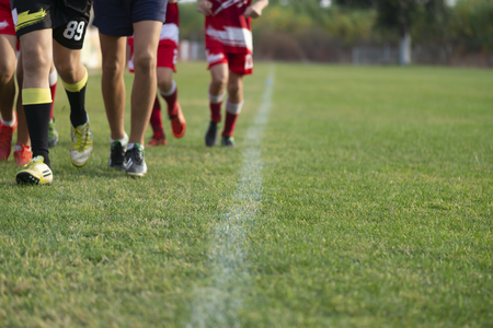 Young football players run in red and white shirtsの写真素材