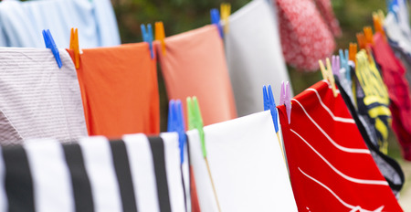 Colorful clothes hanging to dry on a laundry line. Football jerseysの写真素材