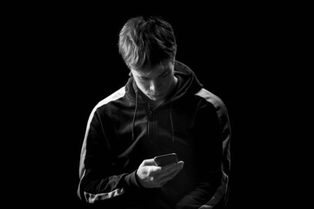 Young man in a sports suit with a smartphone. Studio portrait.の写真素材