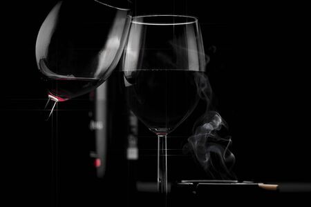 Clinking glasses of red wine in hands on black backgroundの写真素材