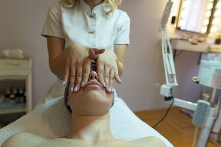 Spa, resort, beauty and health concept - beautiful woman in spa salon getting face treatment. Face skin care. Cosmetology の写真素材