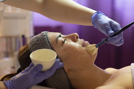 Spa, resort, beauty and health concept - beautiful woman in spa salon getting face treatment. Face skin care. Cosmetology の写真素材