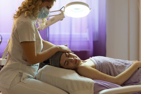 Spa, resort, beauty and health concept - beautiful woman in spa salon getting face treatment. Face skin care. Cosmetology の写真素材