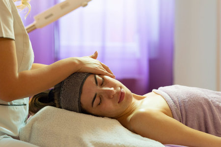 Spa, resort, beauty and health concept - beautiful woman in spa salon getting face treatment. Face...