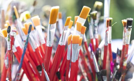 A lot dirty artist paint brushes in a bucket. Different artist brushes, close-up viewの写真素材