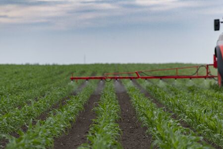 Tractor spray fertilize field with insecticide herbicide chemicals in agriculture field の写真素材