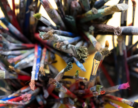 A lot dirty artist paint brushes in a bucket. Different artist brushes, close-up view