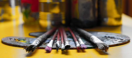 A lot dirty artist paint brushes in a bucket. Different artist brushes, close-up view