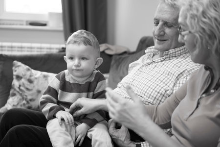 Grandparents with their little grandchild resting at home
