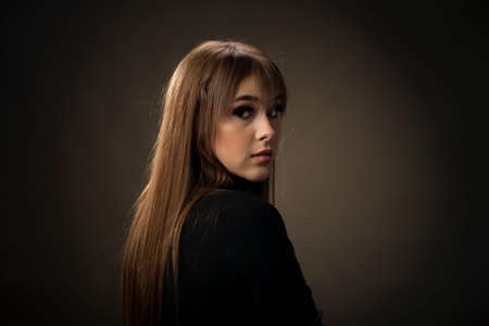Young woman looking at camera isolated on black background. Beautiful woman portrait.の写真素材