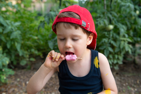 2 year old caucasian boy enjoying a melting chocolate ice-cream on a sweltering hot summer day