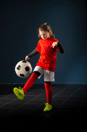 An elementary school girl is playing indoor soccerの写真素材
