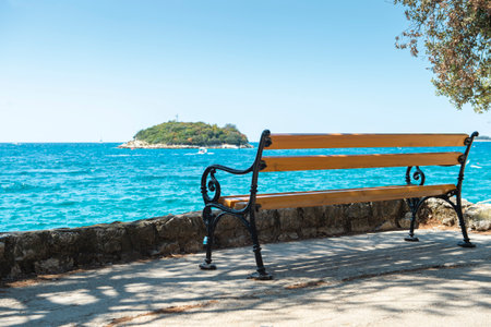 A wooden bench by the sea. Sunny summer day. A place to relax. Vrsar, Istrian peninsula, Croatiaの写真素材