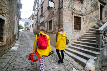 Two women in a small, cobbled street of a beautiful, small town on the Istrian peninsula. GroÅ¾njan, the city of artists, Croatiaの写真素材
