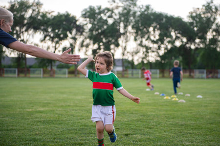 Mom with her son on the soccer field. A parent cares and encourages his child. Sport, outdoor...