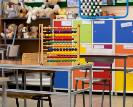 Abacus on a table. Classroom without students with colorful wooden furniture. Education, schoolの写真素材