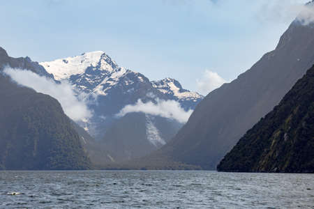 Cloudy landscape with snow-capped mountains in the fjords of the South Island. New Zealandの写真素材