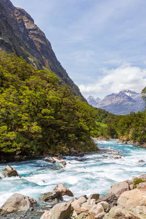 Landscape with a fast river against the background of mountains. Fiordline national park. New Zealandの写真素材