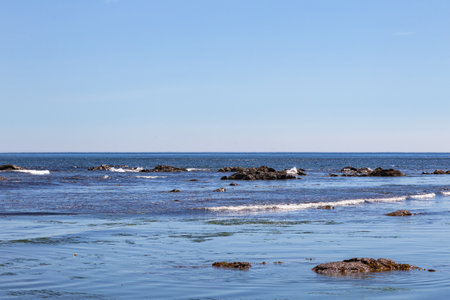 Beautiful seascape with blue sky, sea and rocks. Okhotsk Sea Coast. Rocks, Waves. Sakhalin, Russiaの写真素材