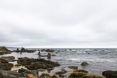 Cape Ostry. A small group of unknown fishermen on the shore. South Sakhalin, Russiaの写真素材
