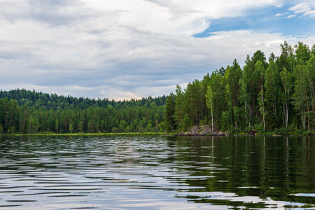 Lake in the forest on a cloudy summer day. Landscape. Landscapes of Lake Tagasuk. Islands on the lake. Siberia, Russiaの写真素材
