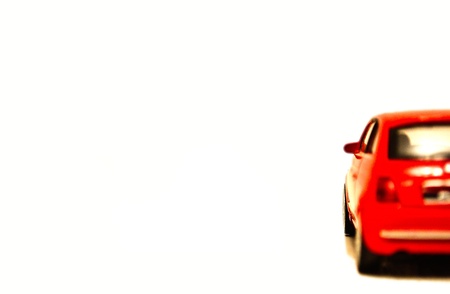 Red toy car on white isolated backgroundの写真素材