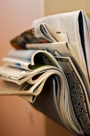 folded and crumpled newspapers and magazines in the wall bracket