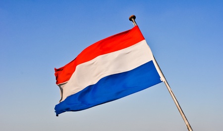 waving flags of Holland against the blue skyの写真素材