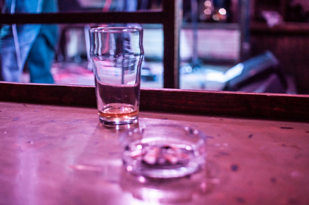 glass and an ashtray on the tableの写真素材