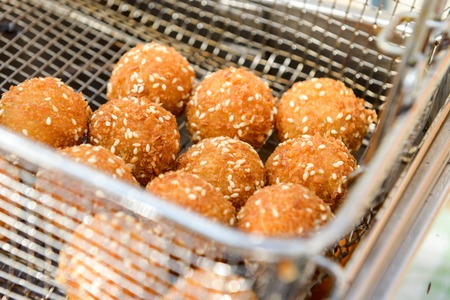 ruddy crispy cheese balls with spices in a metal gridの写真素材